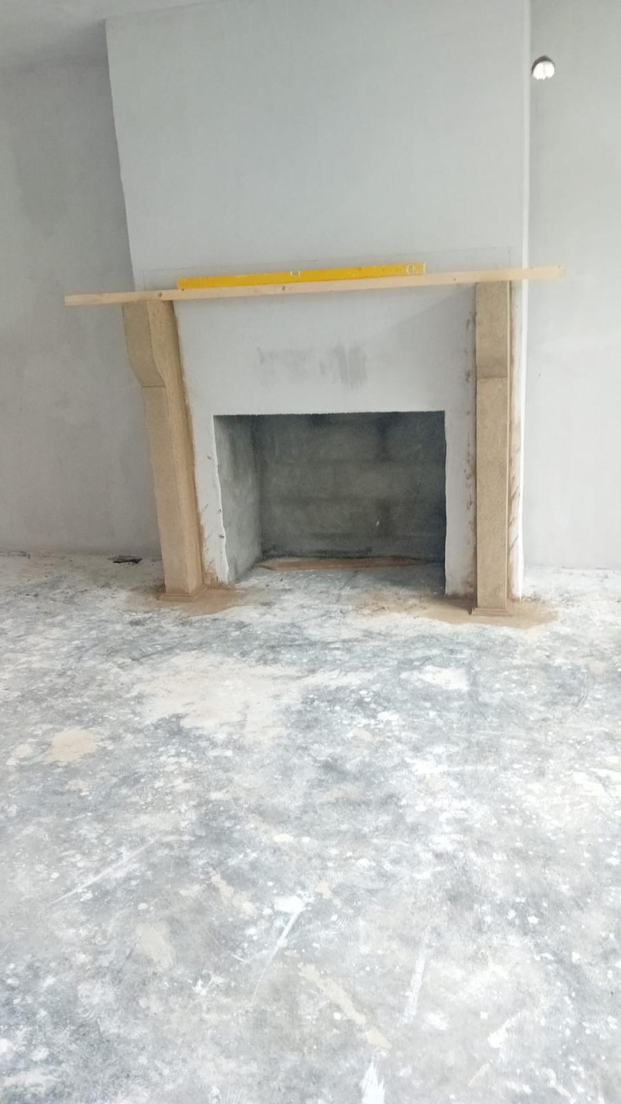 Bespoke fireplace with lintel being levelled during installation