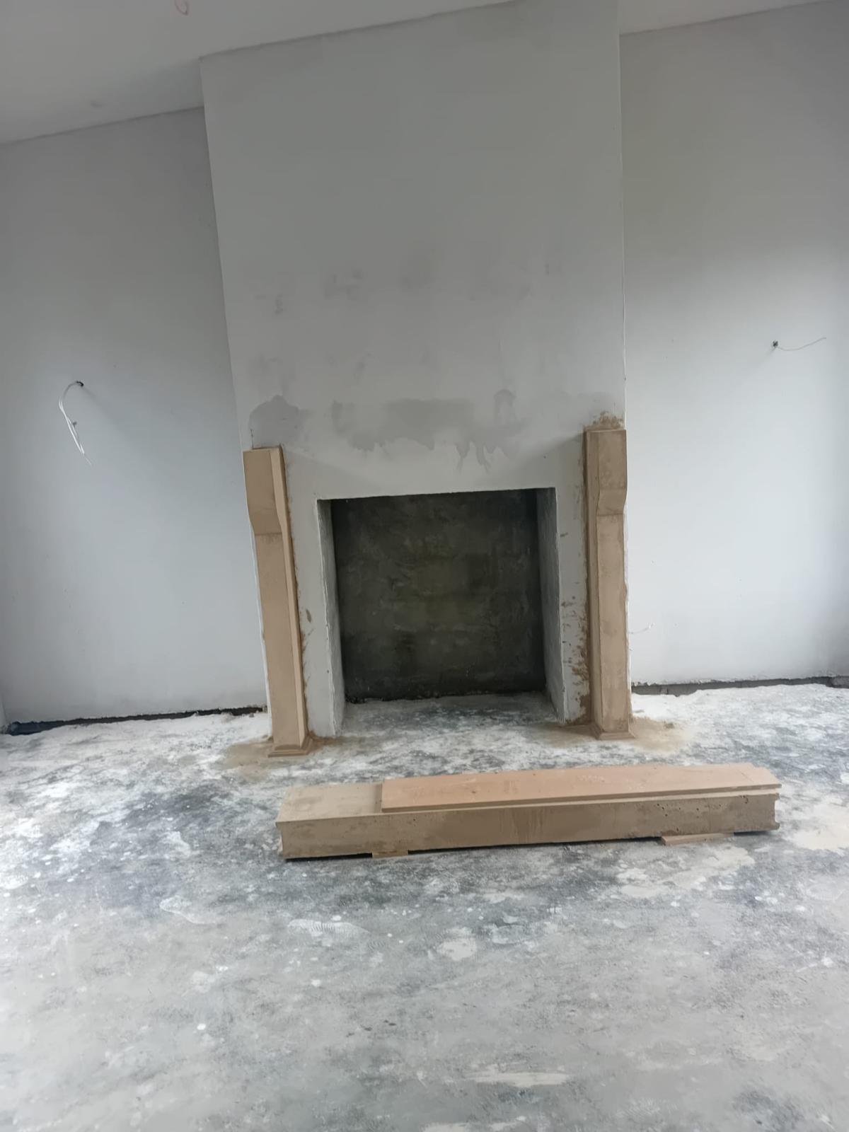Bespoke fireplace jambs hand-modelled in traditional lime materials, awaiting installation of the lintel