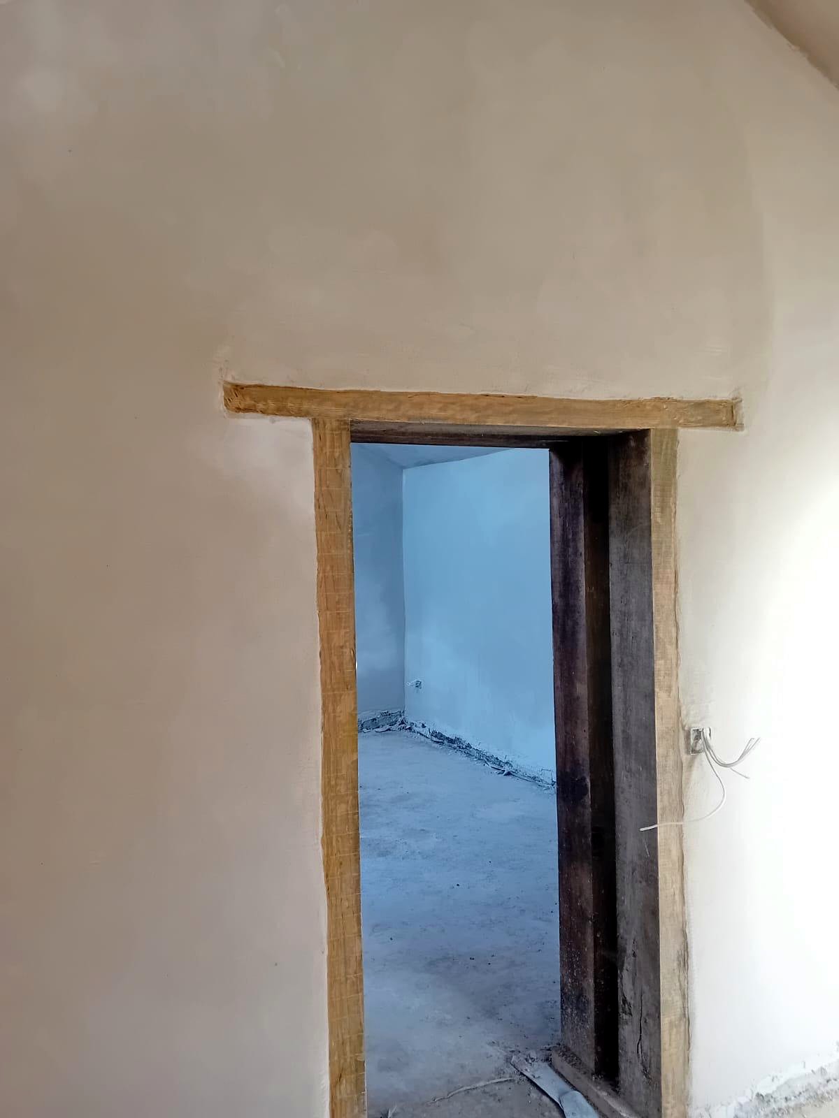 Internal lime plaster finished around a doorway with an oak lintel