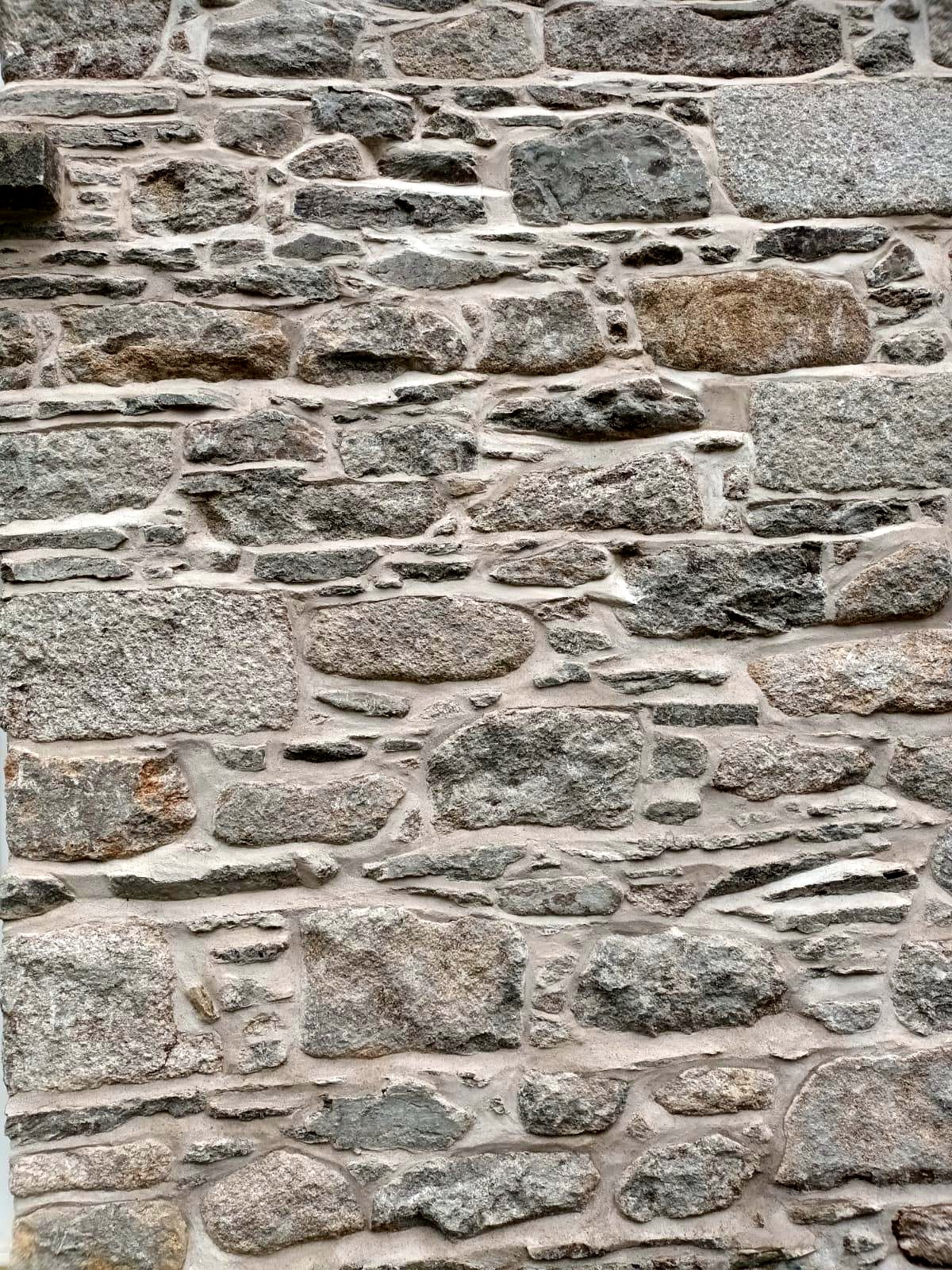 Close-up of finished lime pointing on granite rubble stonework